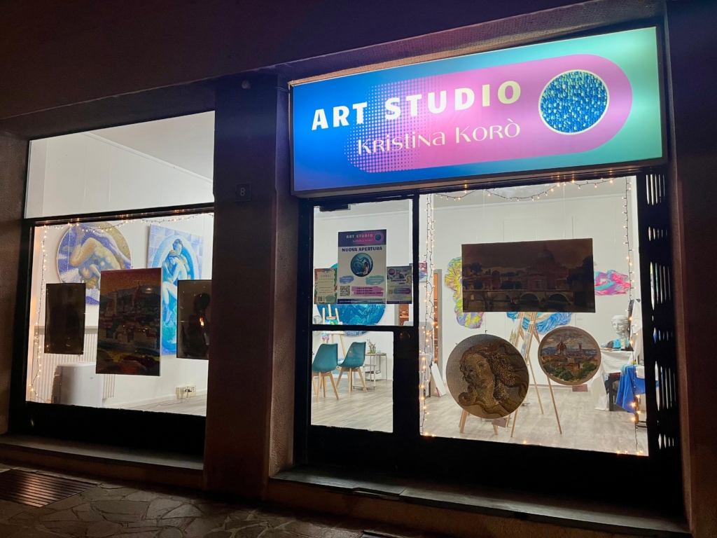 Art studio Korò by night with lights on and sign on